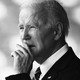 A picture of Joe Biden with his hand in front of his mouth