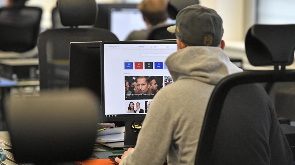 A man looking at Facebook content on a computer screen