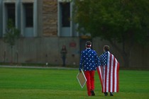 Two boys' backs face the camera. They are wearing American-flag apparel.