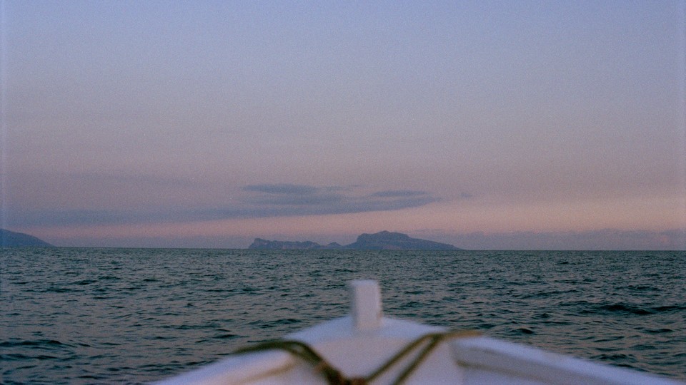 White boat pointed at a sunset