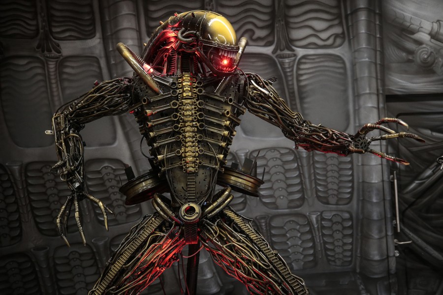 A statue that resembles the alien from the "Alien" movies stands in a theme-park attraction.