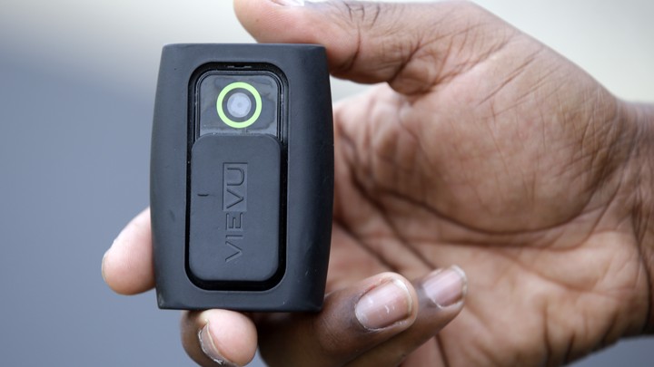 In this file photo taken on Tuesday, Sept. 29, 2015, Whitestown Police Department officer Reggie Thomas holds a body camera that he wears while on his shift, in Whitestown, Ind.