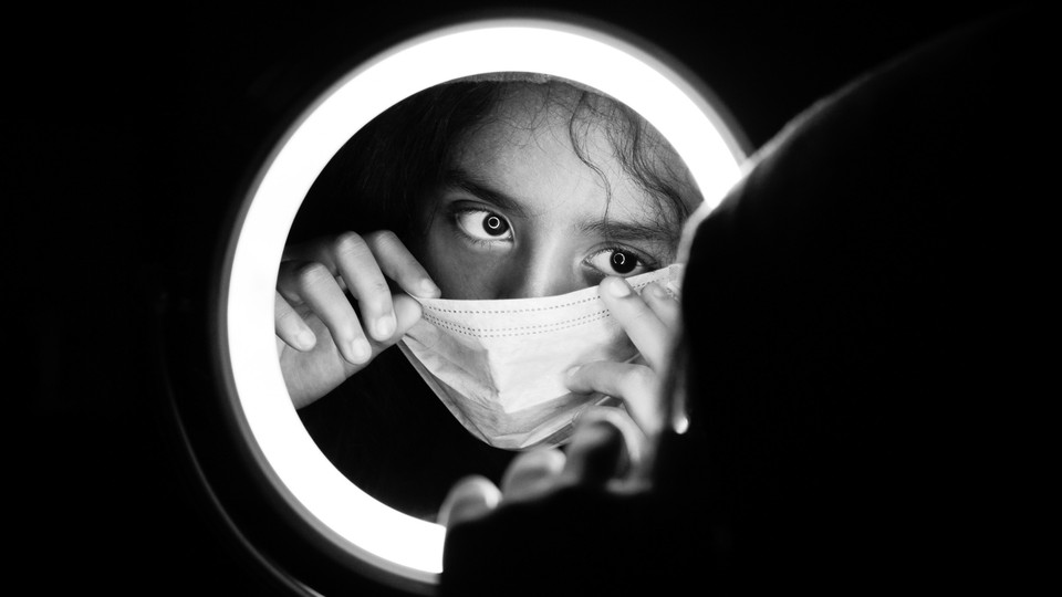 A woman putting on a surgical mask