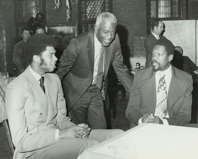 a black and white photo of Kareem Abdul-Jabbar, Jackie Robinson, and Bill Russell