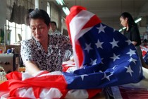 A seamstress sews together an American flag at a factory in Beijing.