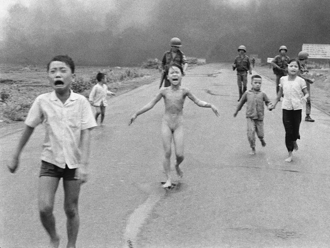 Children run on a street after being hit with Napalm