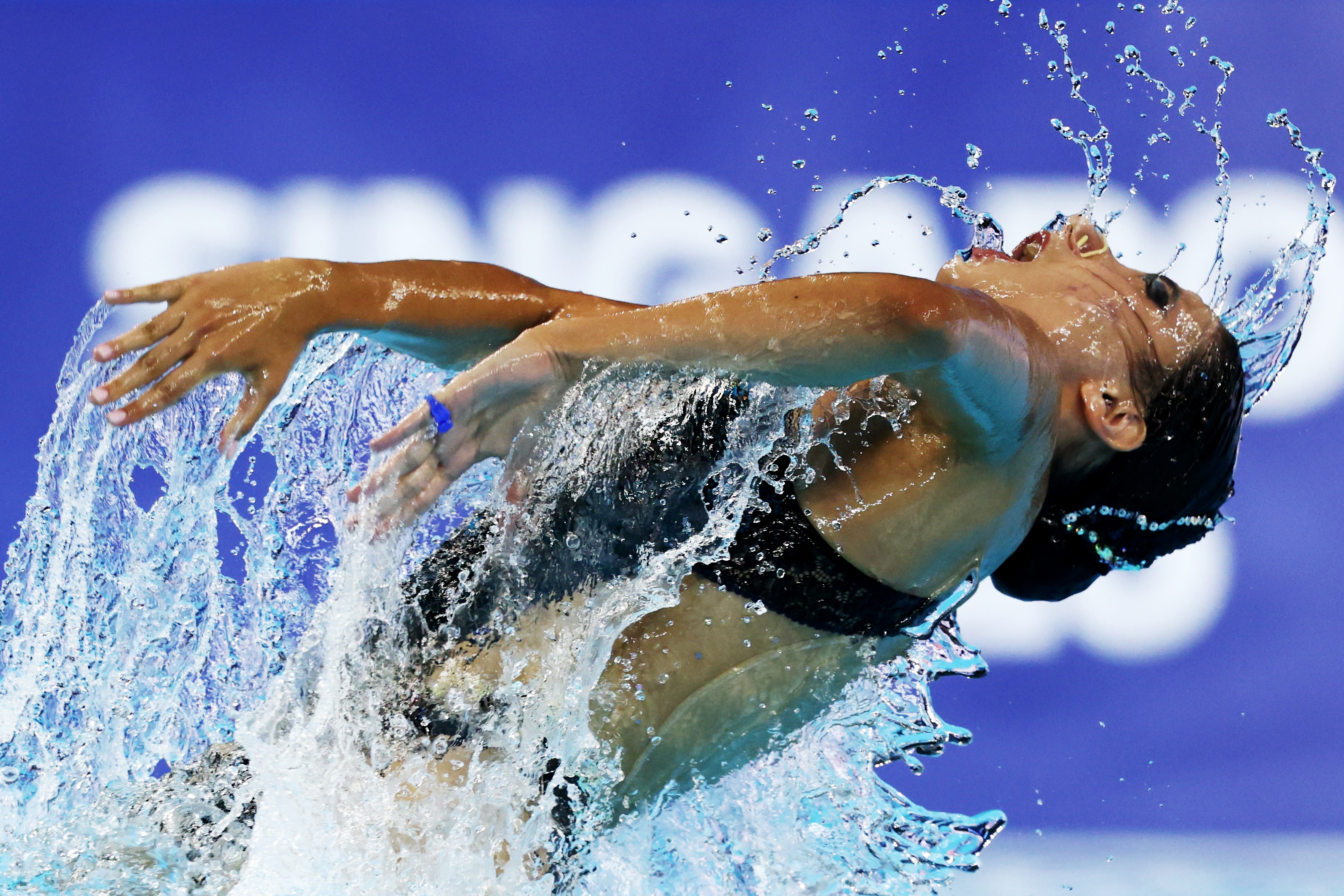A swimmer crashes through the water during a performance.