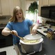A woman cooks with a Crock-Pot in a kitchen.