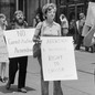 People demonstrate outside a building, with placards that read "No Restrictions on Our Rights" and "Abortion: A Woman's Right to Choose."