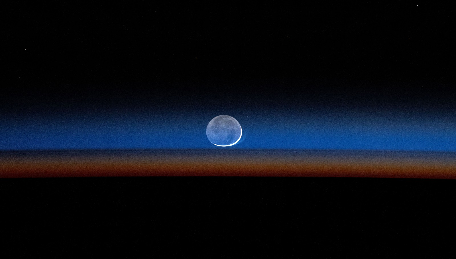 A new moon, seen near the Earth's horizon.
