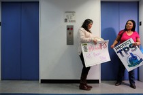 Two Salvadoran immigrants wait for an elevator.