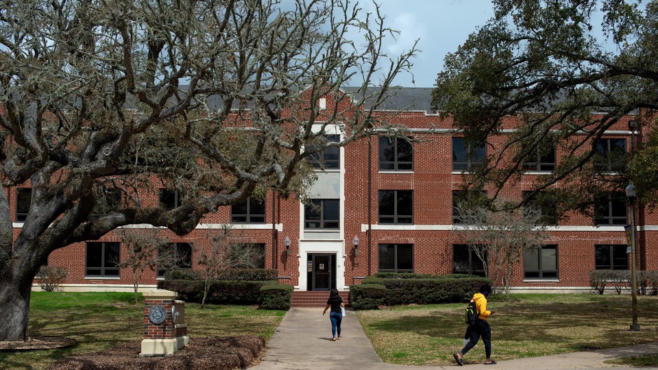 Two students walk near a building at Prairie View A&M University.