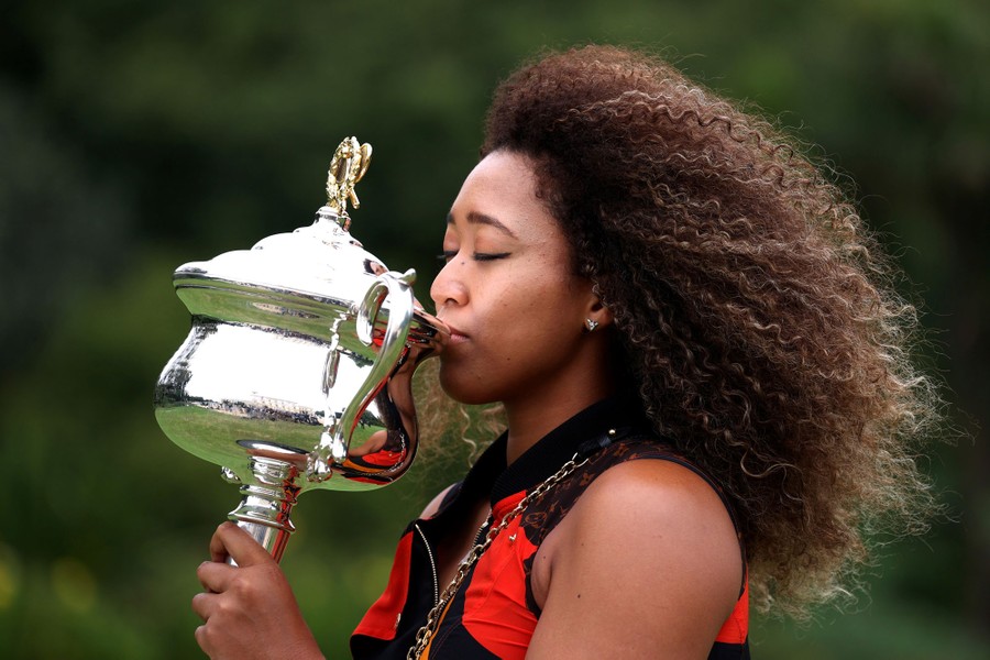 Naomi Osaka poses with a trophy.