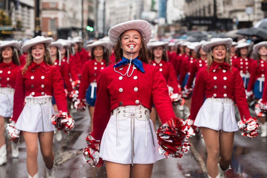Members of a college drill team wearing bright costumes march in a parade.