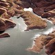 A low river flows at the bottom of a drought-stricken southwestern canyon.