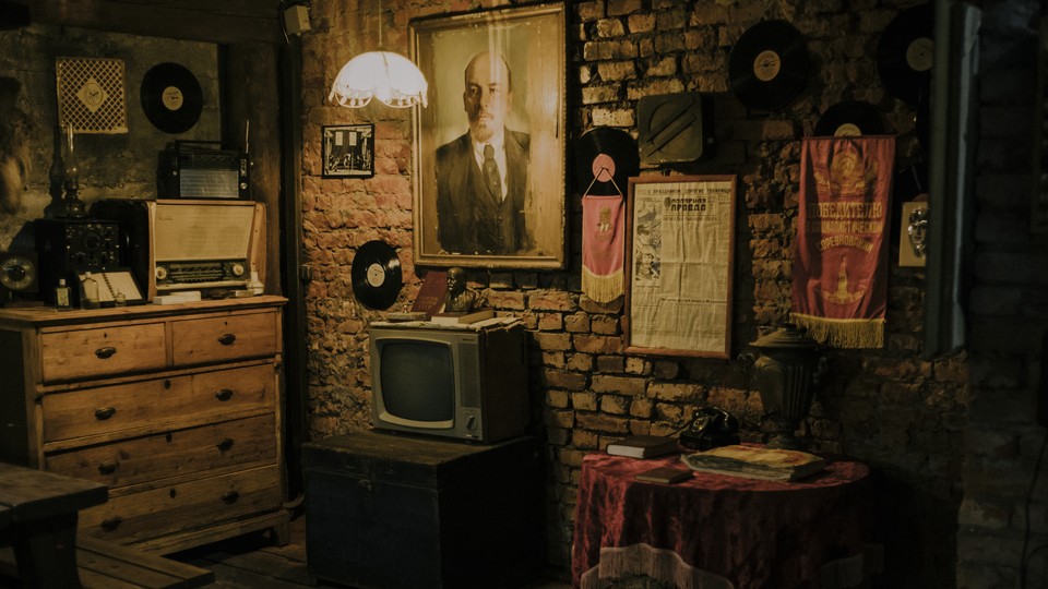 Living room featuring a TV and a portrait of Lenin
