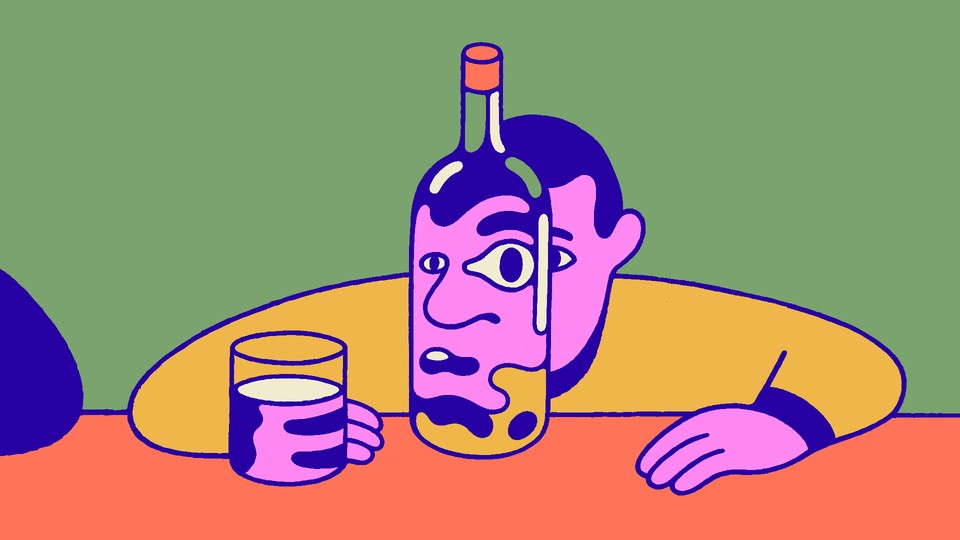 A man sitting at a bar looking through a bottle of booze