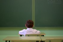 A young boy sitting at his desk