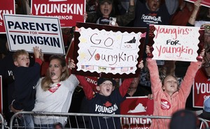 People holding signs reading "Parents for Youngkin," "Go Youngkin," and "Youngins for Youngkin"