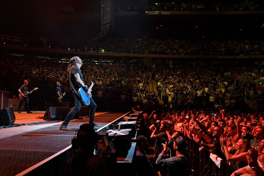 Dave Grohl and his bandmates perform onstage in front of a large crowd.