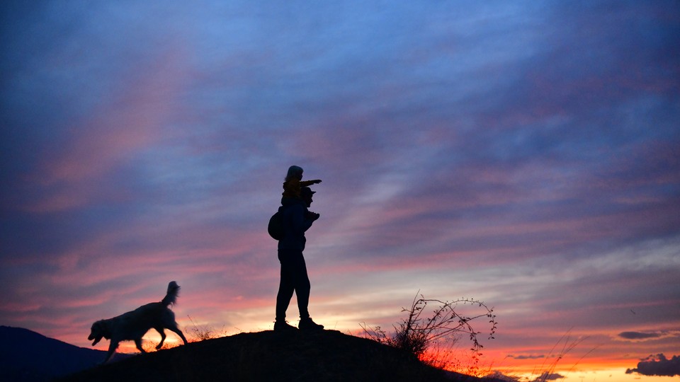 A father and son walk at dusk