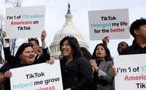An image of people holding pro-TikTok signs in front of the Capitol