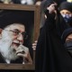 Women in chadors surround a large framed photograph of Ayatollah Ali Khamenei