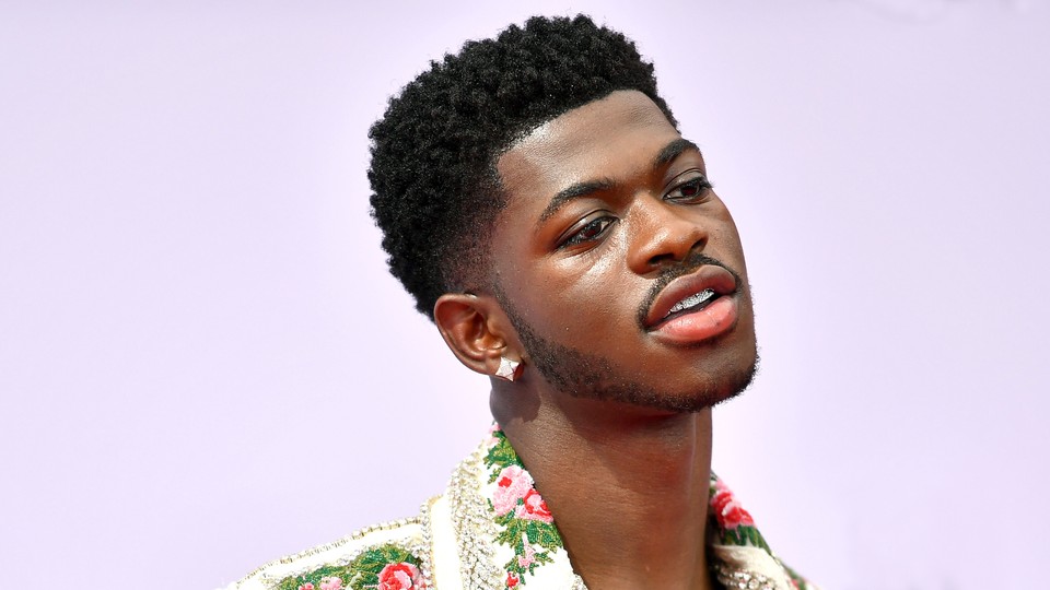 Lil Nas X against a light purple background