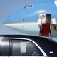 Photo of Donald Trump in a black car with Air Force One in the background