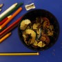 Colored pencils alongside a sharpener and a bowl of shavings