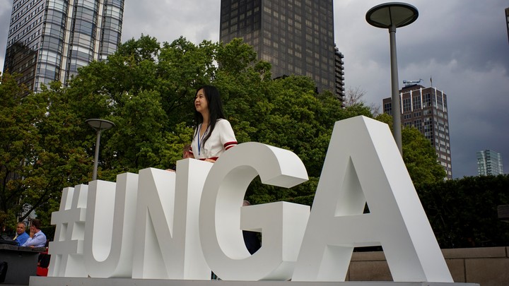 A woman stands at the grounds of the United Nations headquarters.