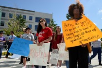 Protesters gather at a university with signs protesting Betsy DeVos and her plans for campus sexual-assault policies.