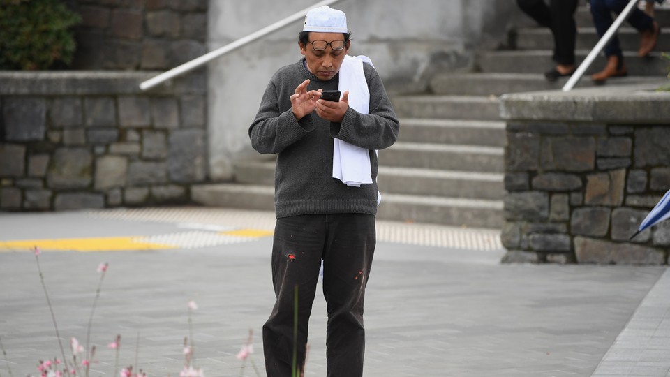 A survivor of the shooting at Al Noor mosque in Christchurch, New Zealand, waits for his wife to pick him up.