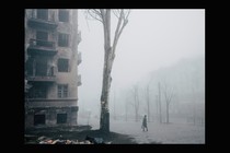 A woman walks past a destroyed building in Mariupol.