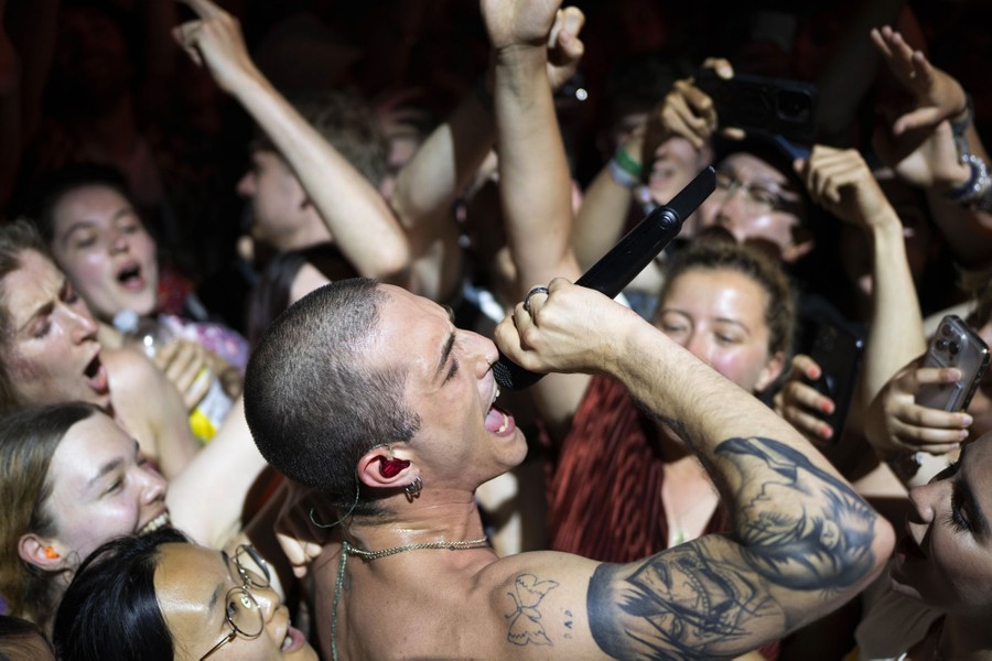 A singer performs in the middle of cheering fans.
