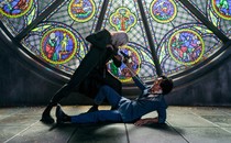 Two characters from 'Cowboy Bebop' in a standoff in front of a stained-glass window