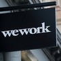 A WeWork sign against some tan buildings