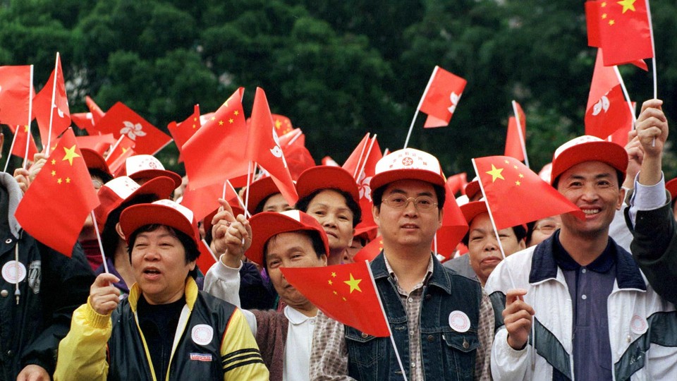 A large group of people wave Chinese flags.