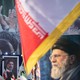 A color photo showing portraits of Ayatollah Ali Khamenei displayed alongside Iranian flags at a rally.