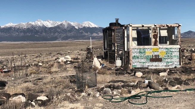 Une cabane avec des montagnes en arrière-plan