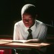 a boy reading a book at a desk